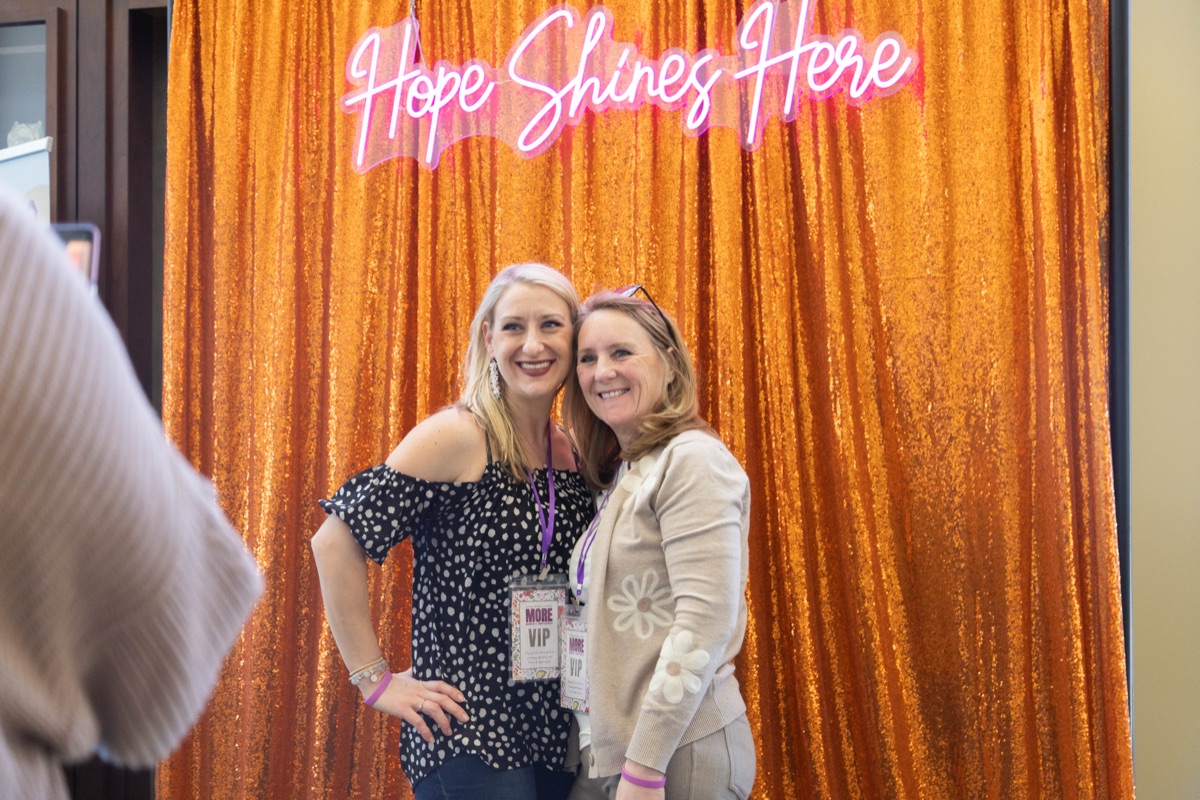 Friends smiling at the Hope Shines Here photo backdrop